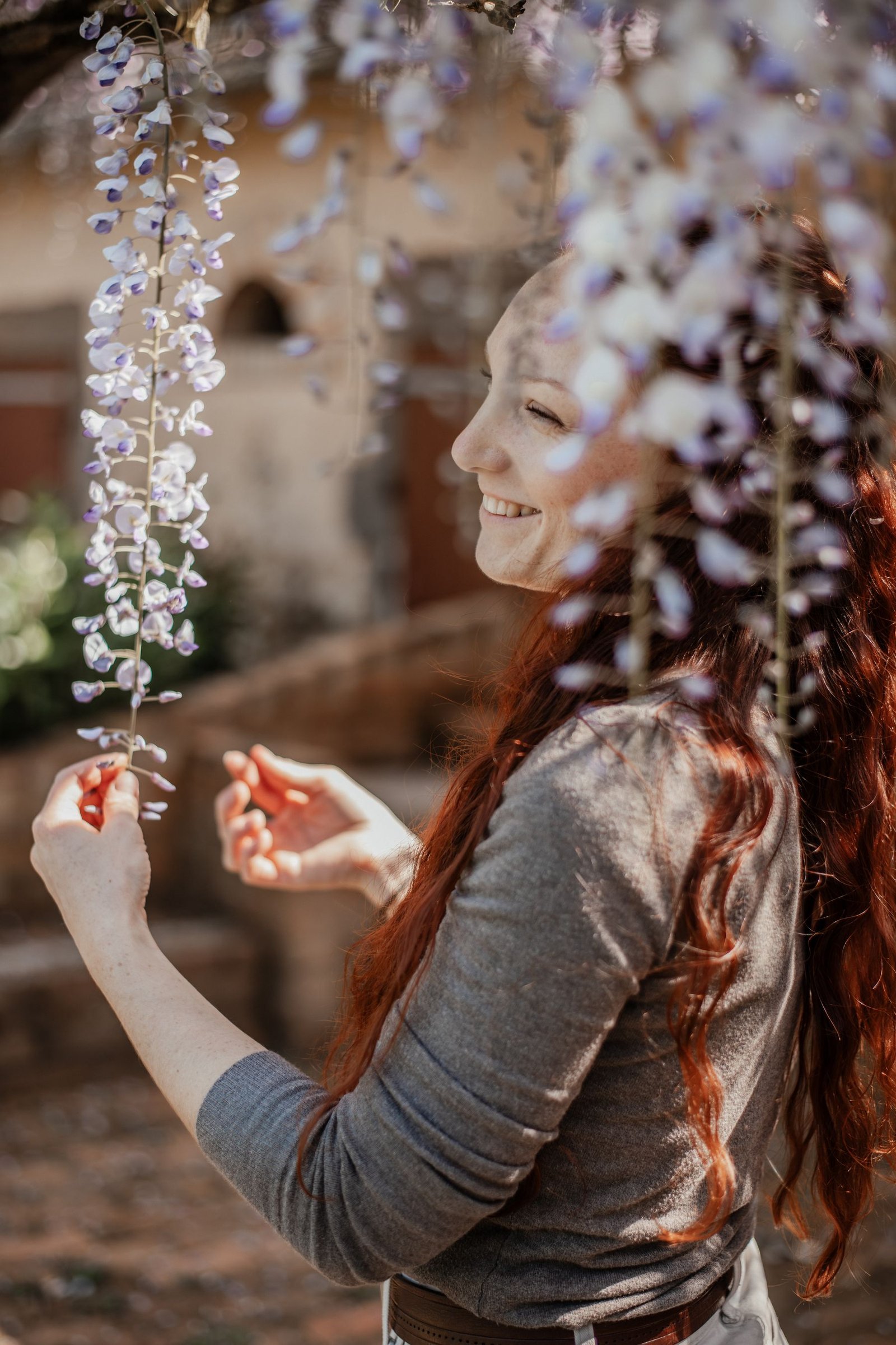 Laura Bridier souriante sous une glycine en fleurs.